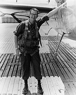 Black and white picture of veteran standing next to plane.