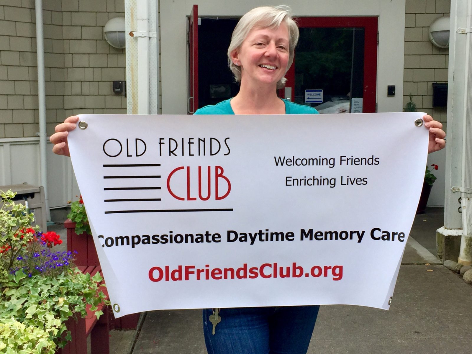 Karen Koenig holding banner of Old Friends Club