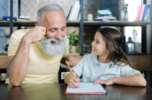Careful grandfather helping kid with home assignment