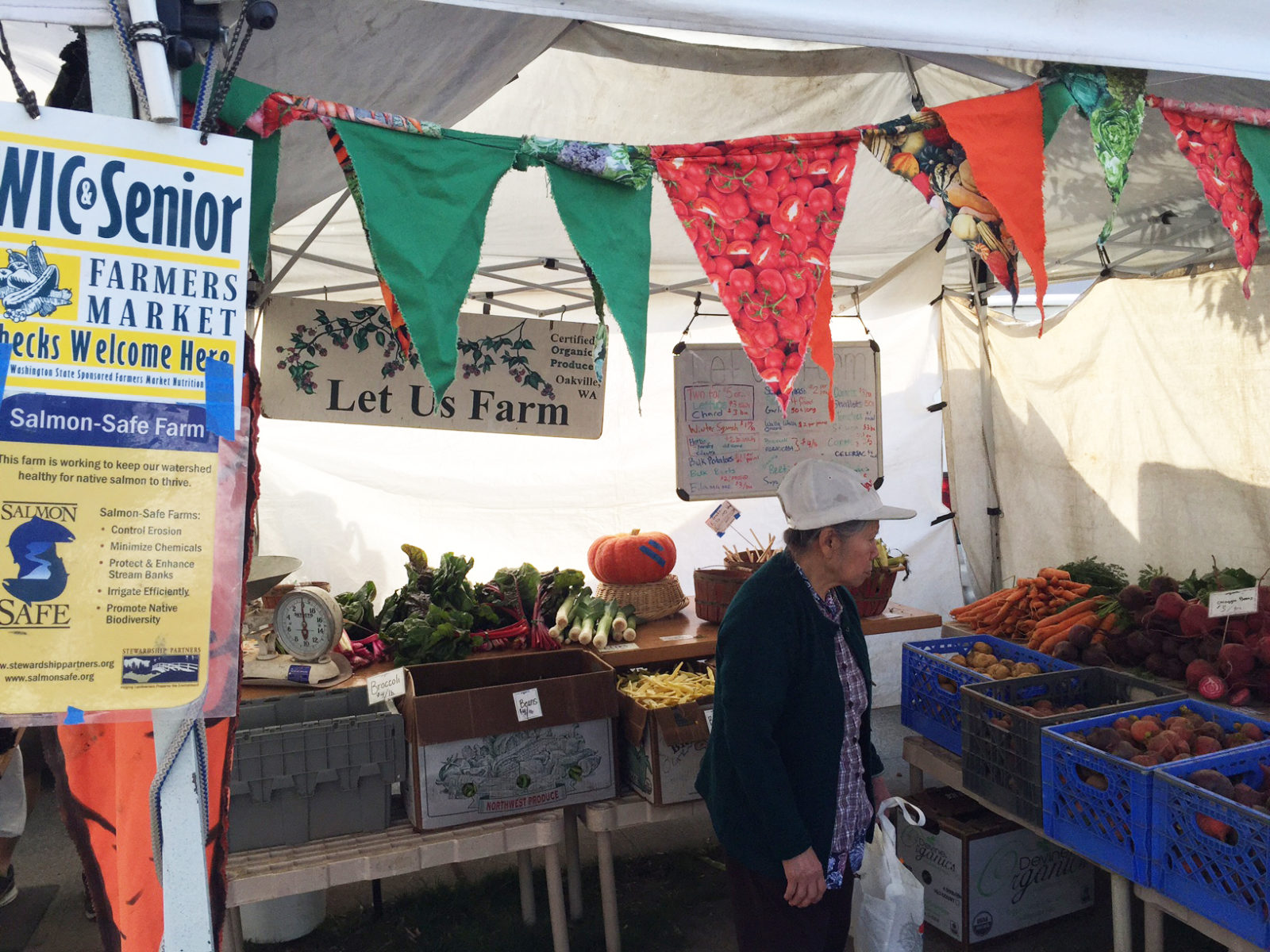 photo from a local farmers market shows fresh produce and a sign for the Senior Farmers Market Nutrition Program described in this article