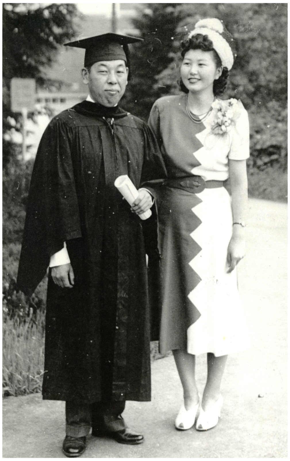 Black and white photo of George and Ayame Tsutakawa. He wears and graduation robe and mortar board.