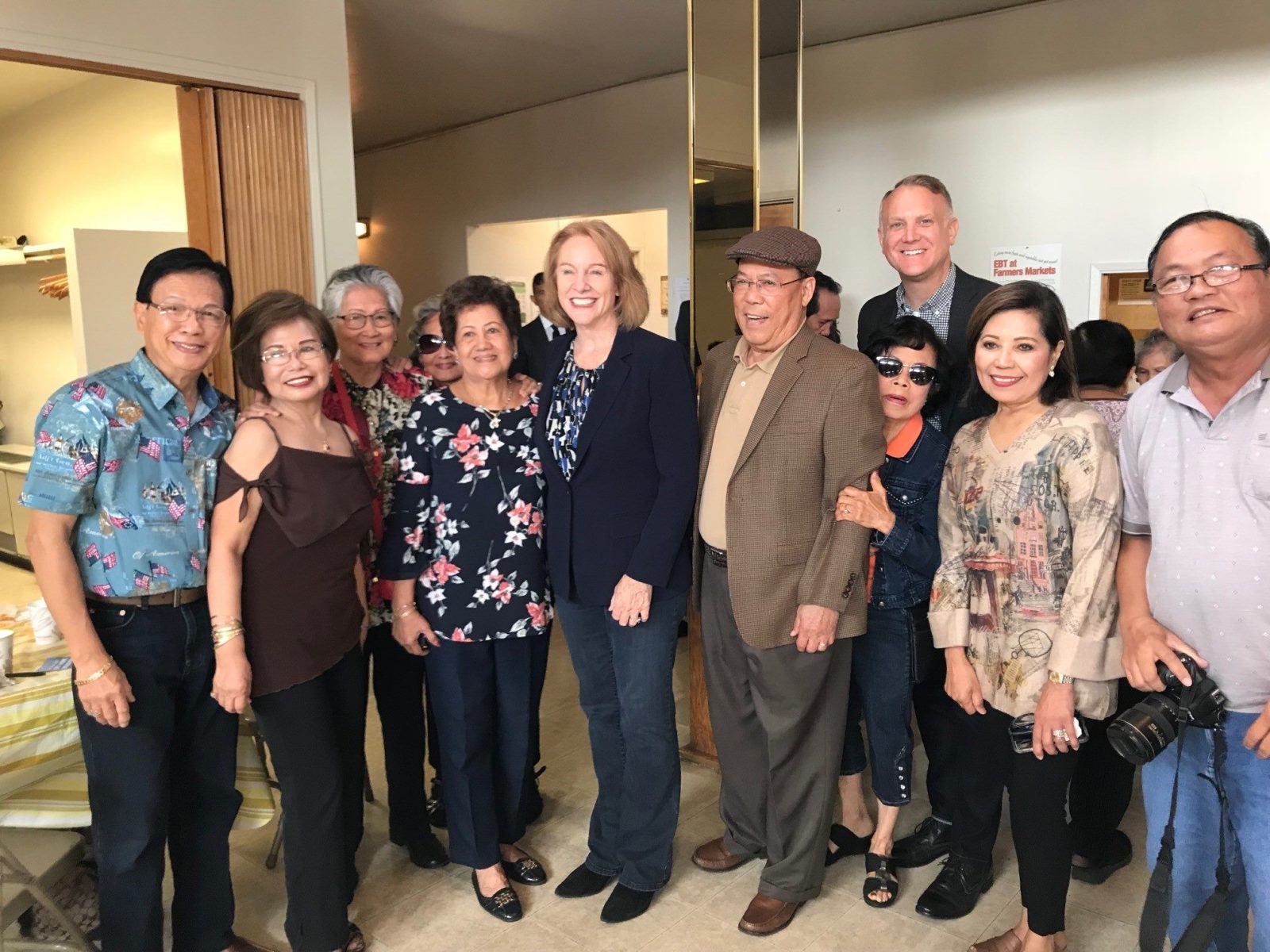 photo of Seattle Mayor Jenny Durkan, Seattle Human Services Department interim director Jason Johnson, and about seven participants at the International Drop-In Center or I D I C.