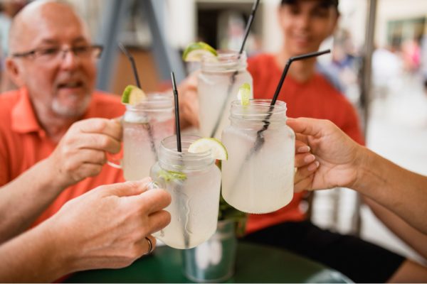 Group of people, mixed ages, toasting each other with mugs of lemonade