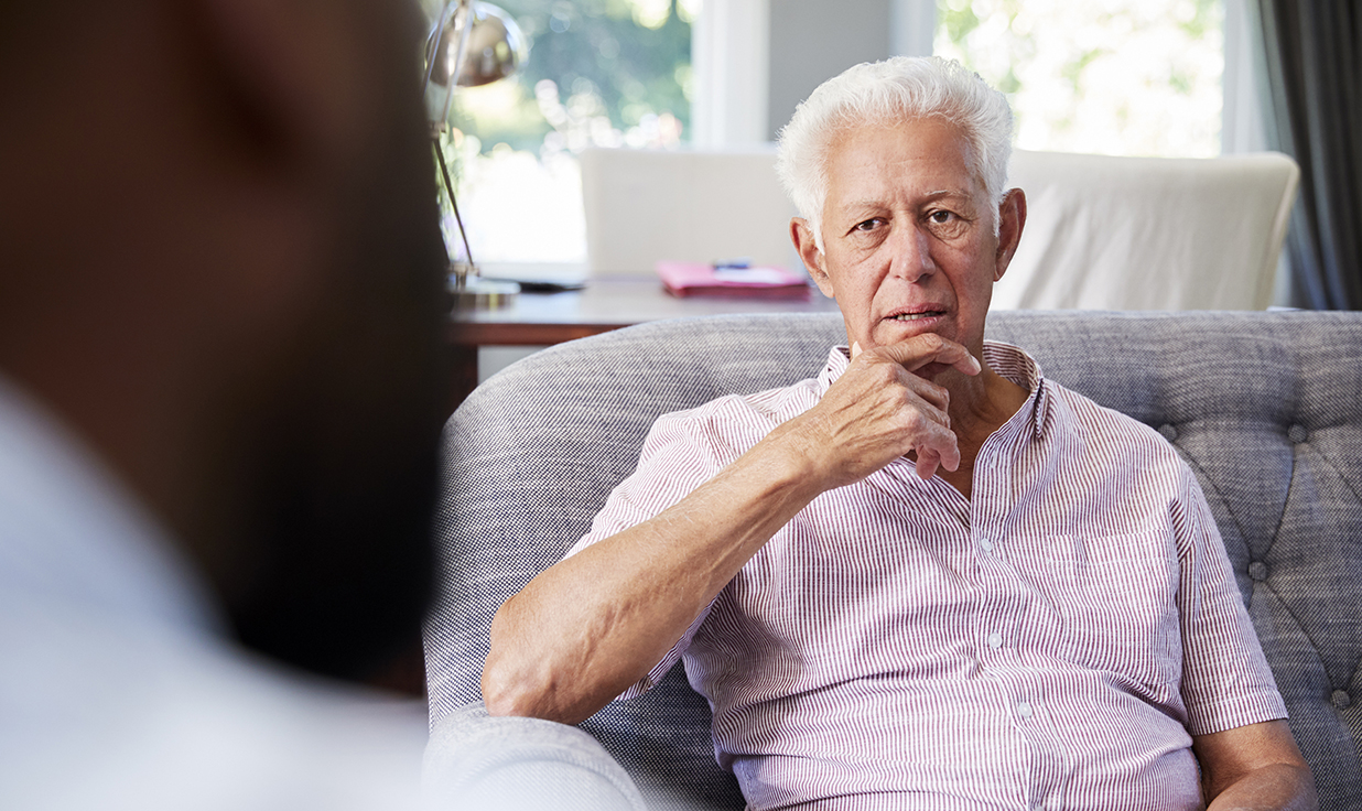 Older man having a discussion, looks a little sad