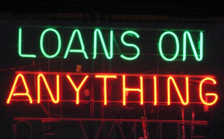 glowing neon sign says Loans on Anything