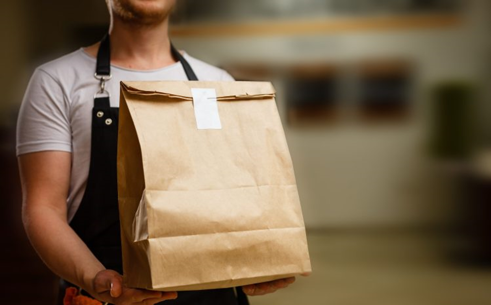 delivery person with large grocery bag and receipt