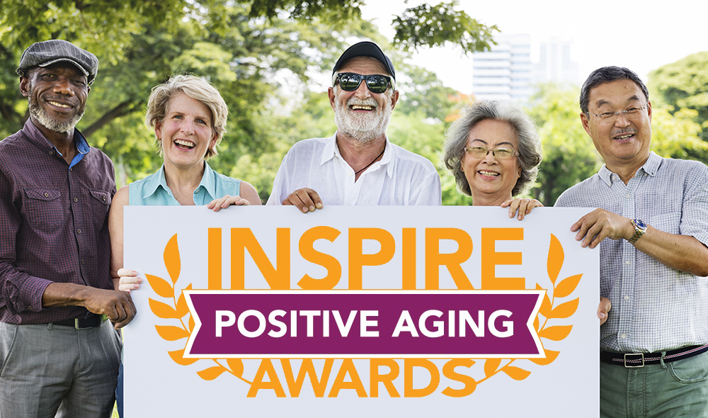 Five older women and men holding a banner for the Inspire Positive Aging Awards