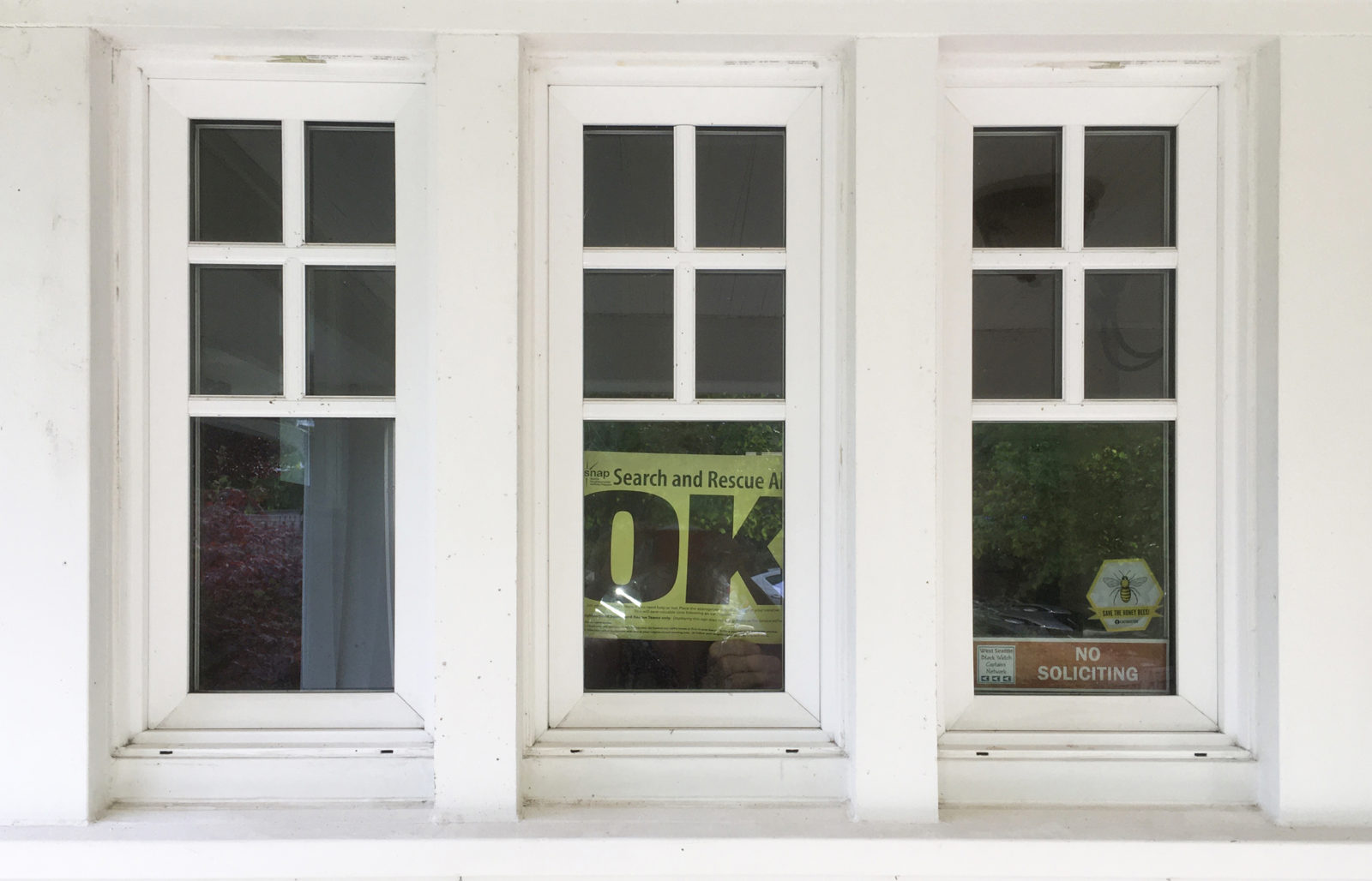 3 multipane windows with a search and rescue "OK" sign in the middle