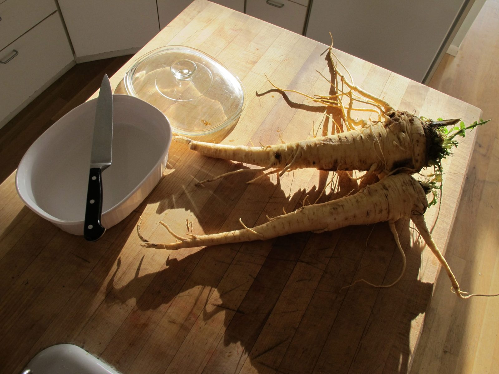 Two parsnips on a kitchen cutting board