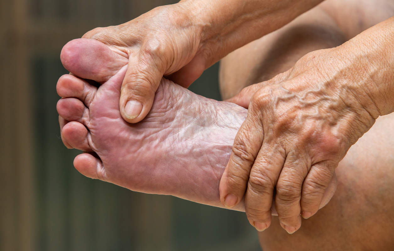 older woman's hands massaging her foot,