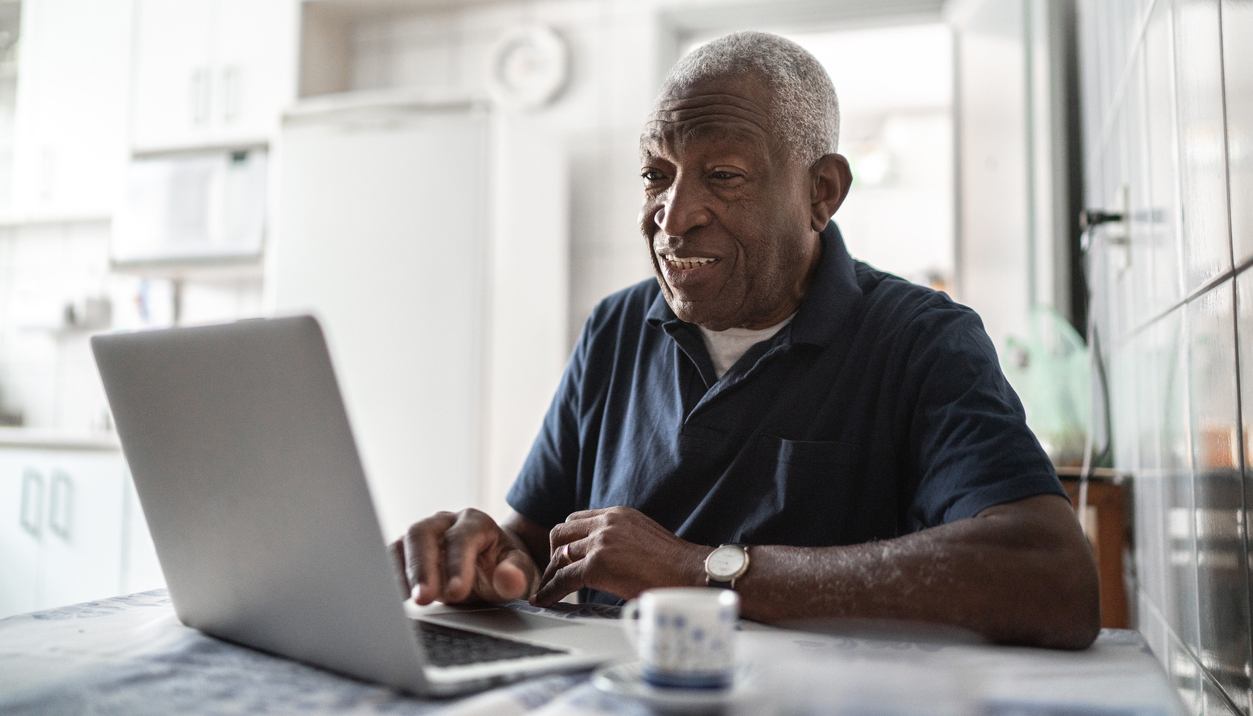 Older man working at laptop at home
