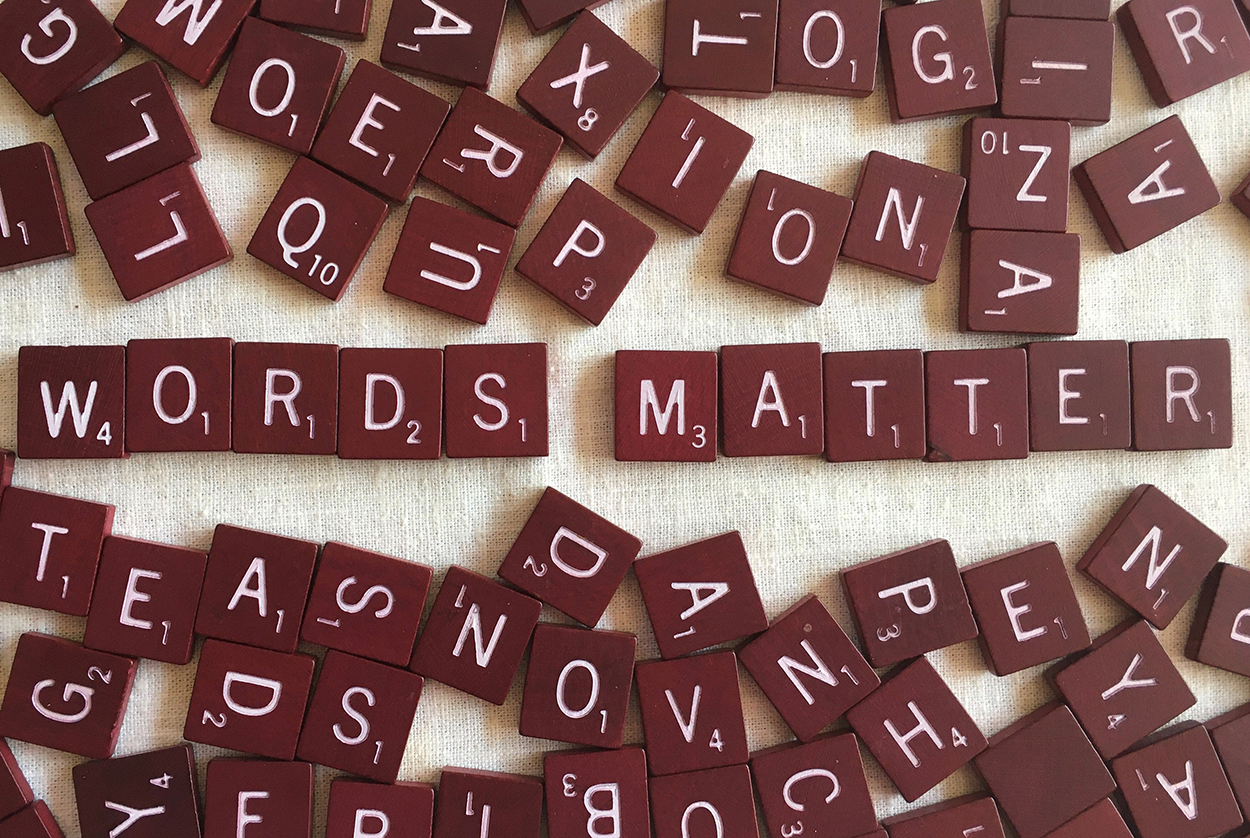 scattered Scrabble tiles with two words at center - Words Matter