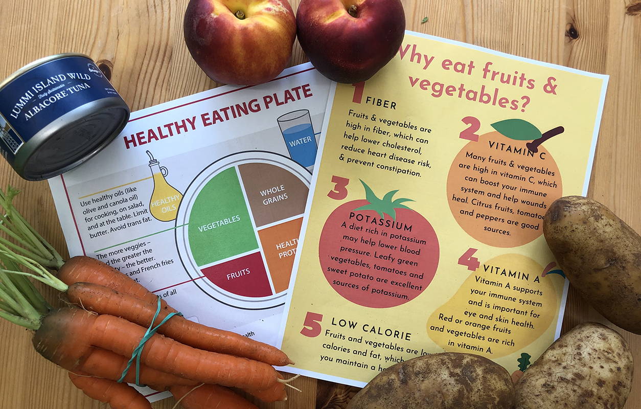 Two nutritional information flyers surrounded by healthy food items