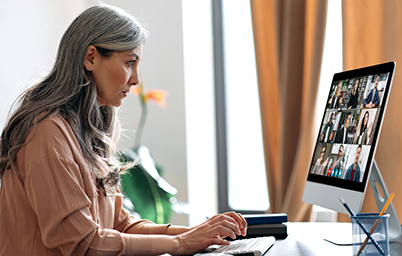 older woman participates in virtual meeting on her computer