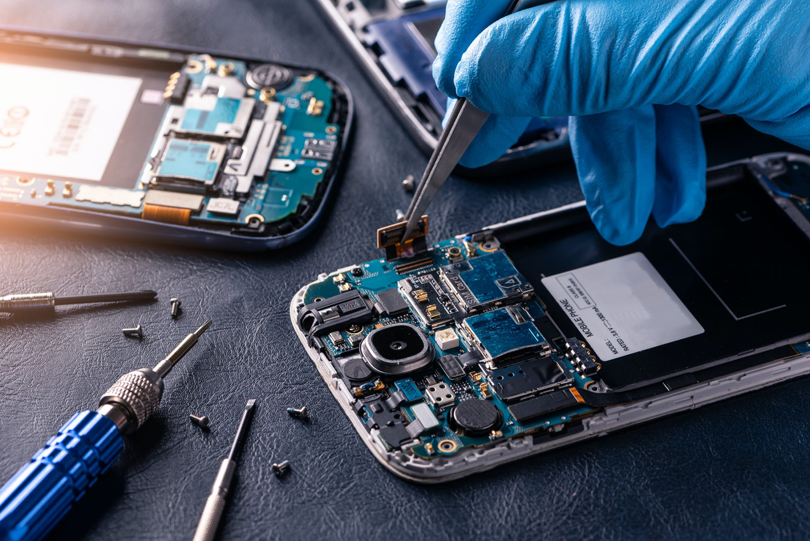 technician works to repair the interior of a cell phone
