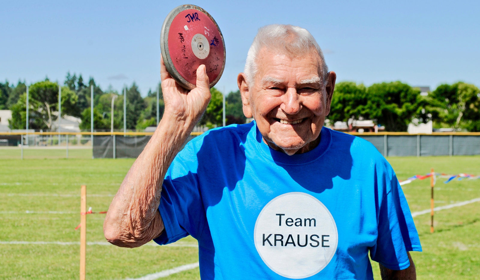 Senior Games competitor Leonard Krause in 2021 (age 100), holding a discus over his head