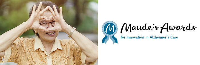 middle-aged Asian woman holds her hands in the shape of a heart in front of her smiing face - Maude's Awards for Innovation in Alzheimer's Care