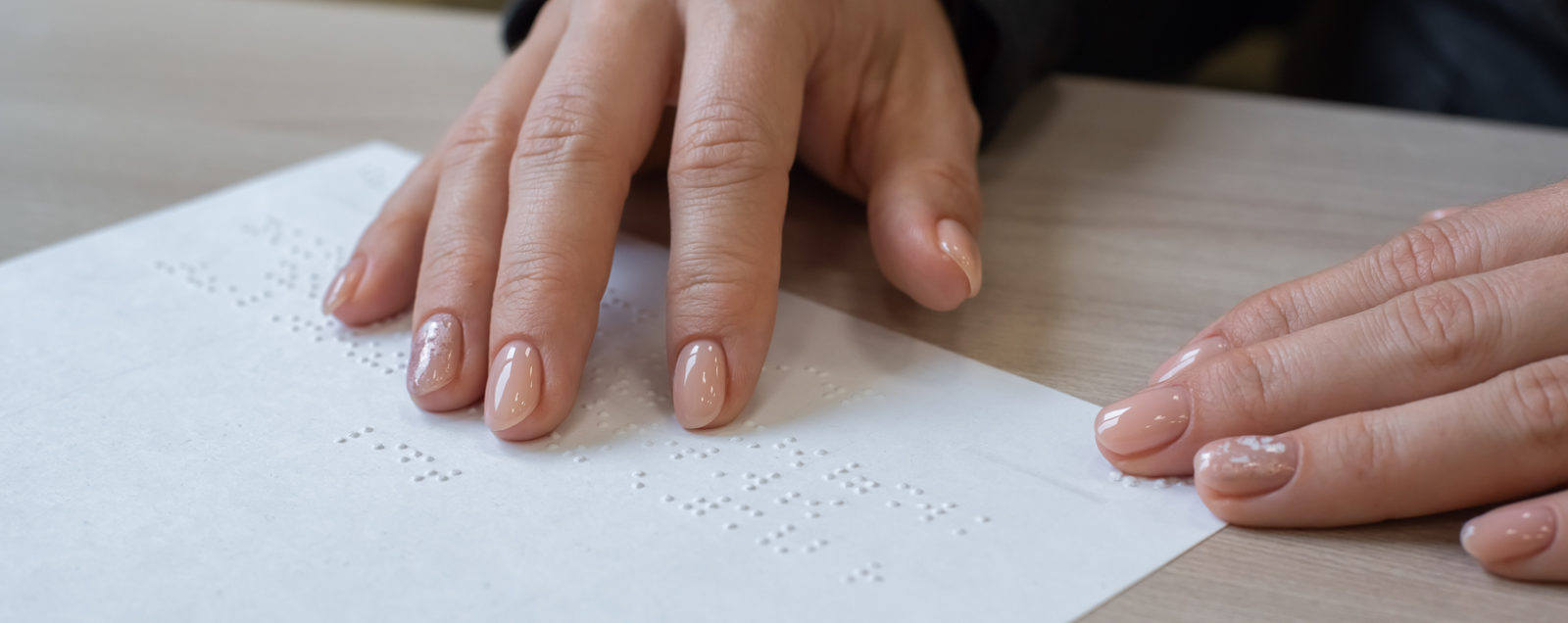Two hands reading Braille