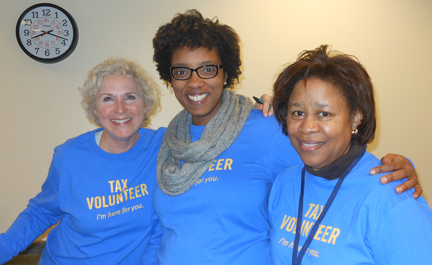 Three smiling women wearing United Way Tax Prep volunteer t-shirts