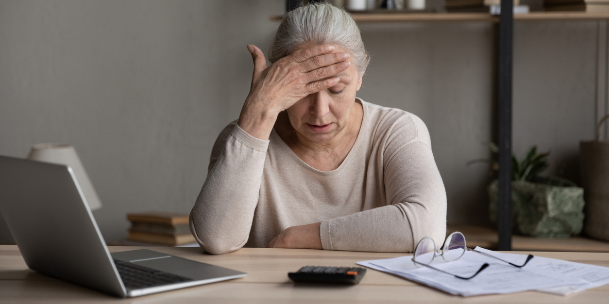 older woman looks stressed and worried about finances