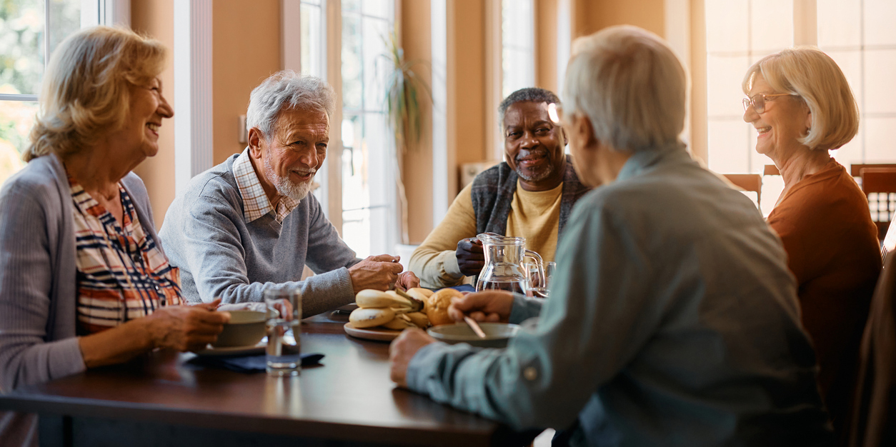 Five older people enjoying lunch together