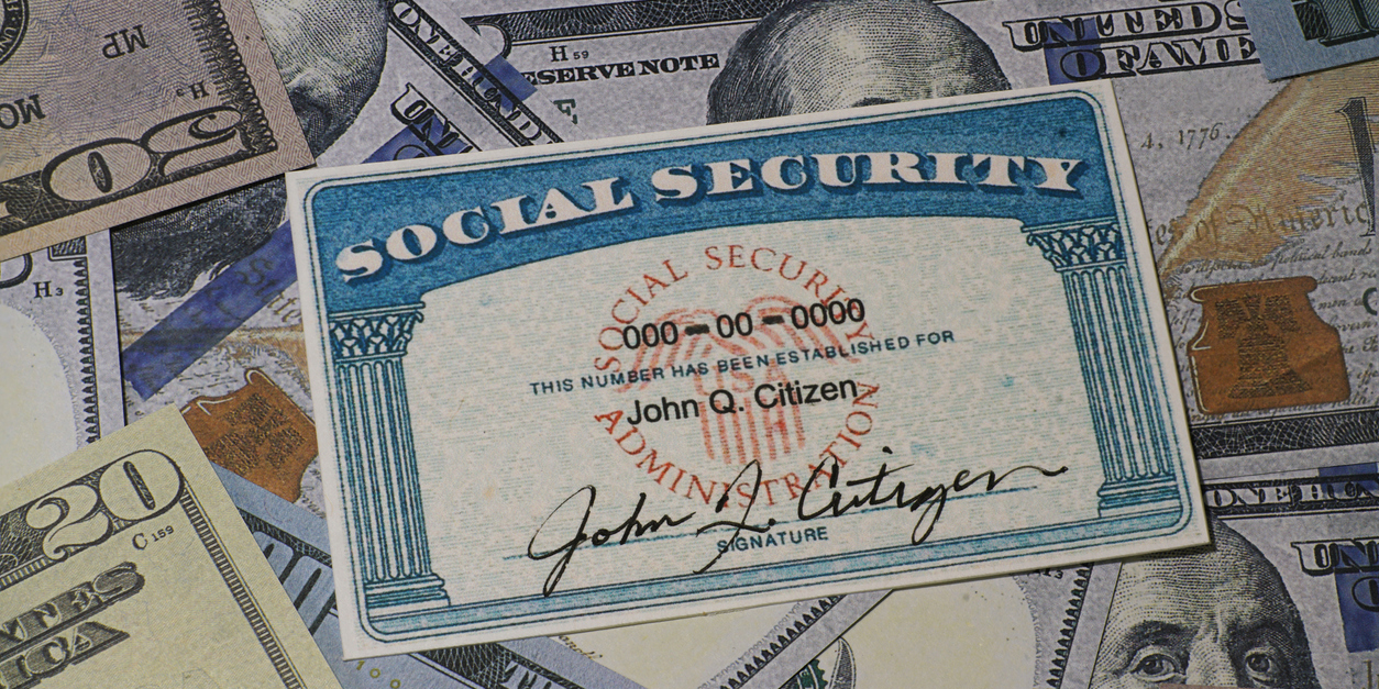 Social Security card for John Q. Citizen laying on top of a pile of cash