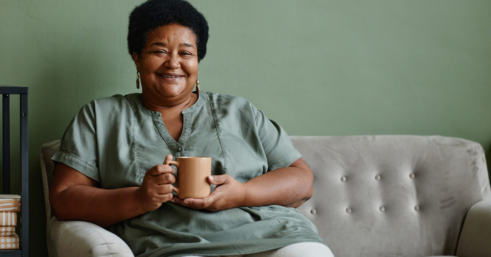 smiling woman on couch with coffee mug