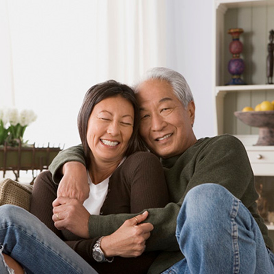 happy Asian couple sitting on a couch
