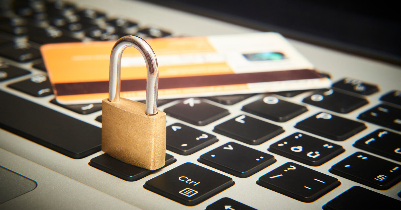 Credit card and padlock resting on a computer keyboard
